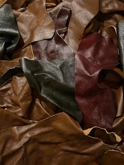 A pile of leather in various shades of brown, burgundy, dark green and black.